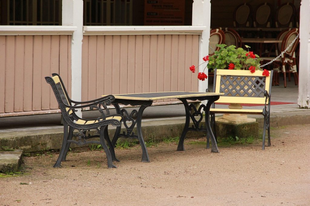 There are two yellow chairs and a table outdoors