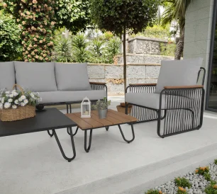 A modern outdoor patio furniture set with a gray sofa, chairs, and coffee table in a garden space